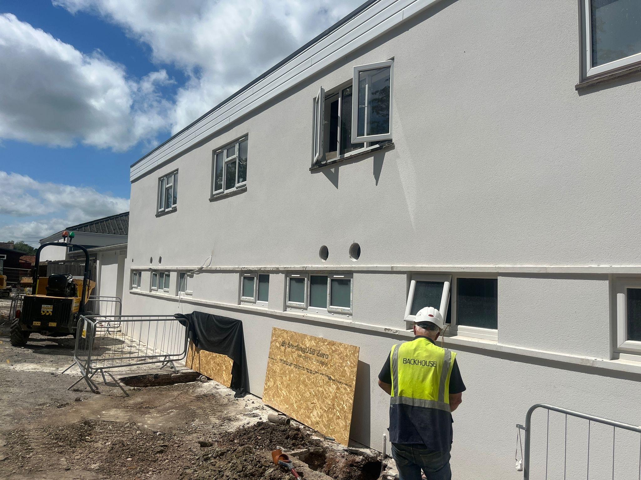 K&R working outside of white building preparing health and safety