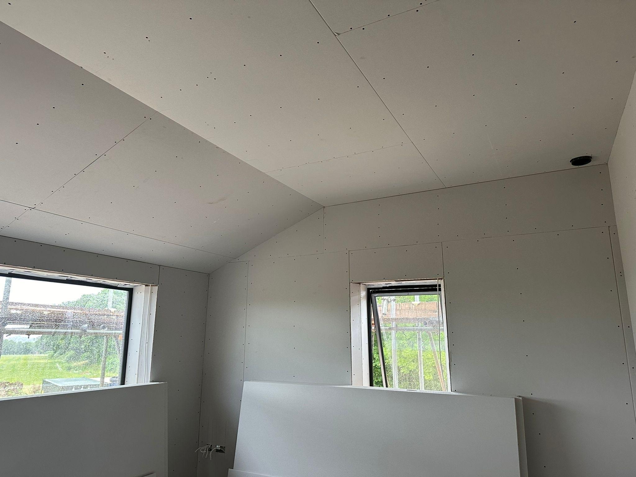 Boarded ceiling and walls with two windows